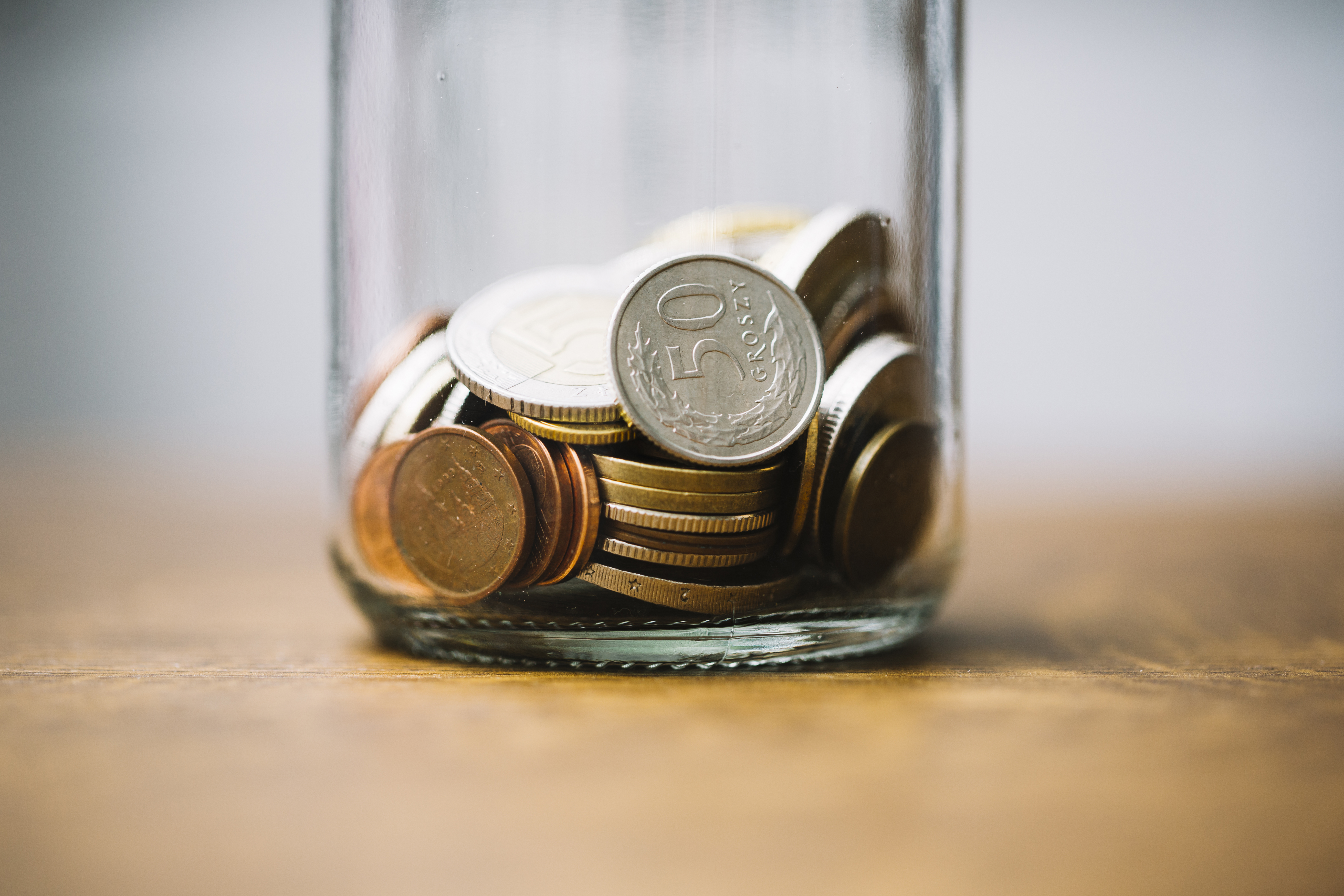 close-up-collected-coins-glass-jar-table