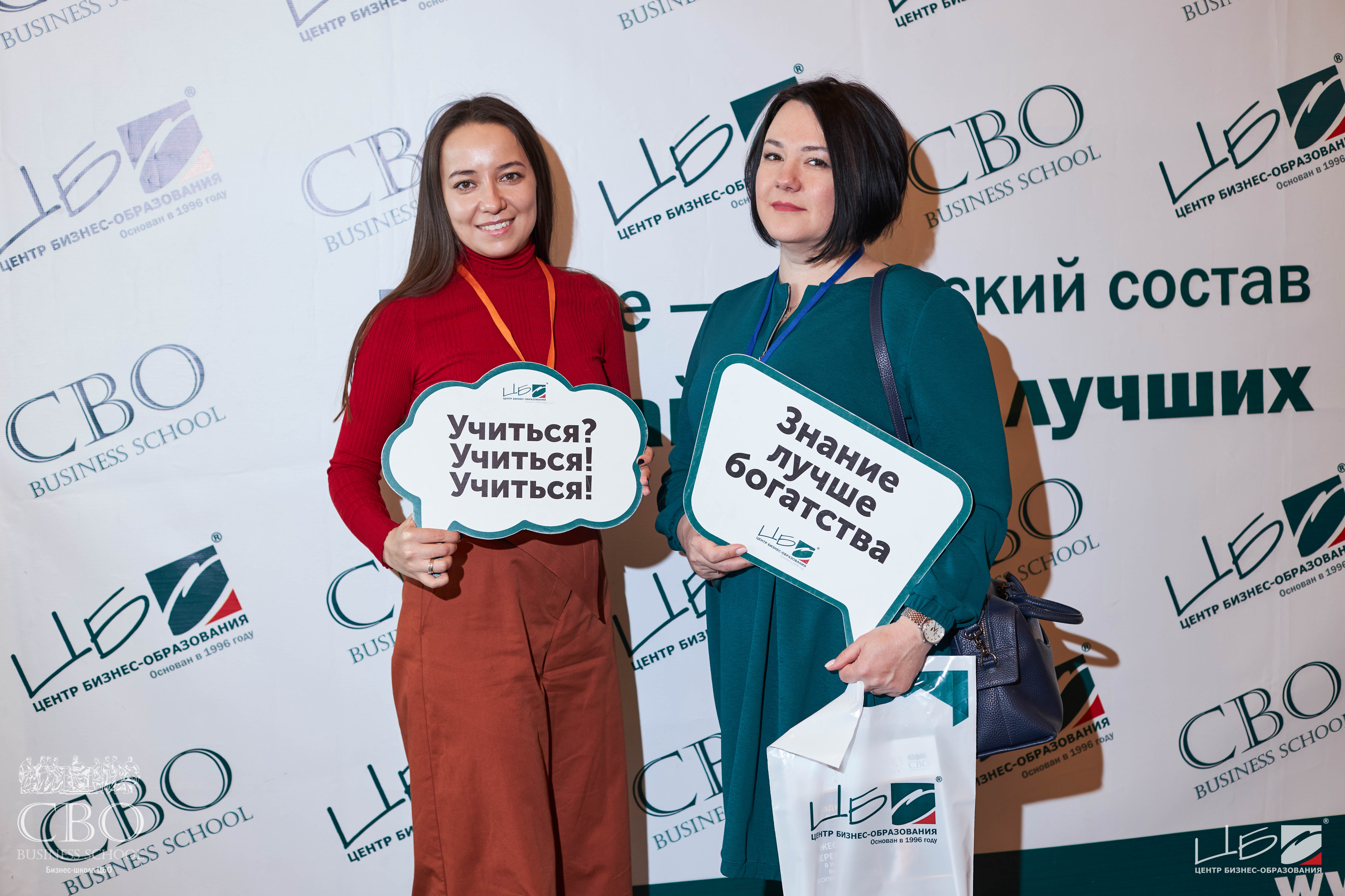 Программа MBA Бизнес-школа ЦБО Студенты ЦБО на фоне стенда с табличками в руках