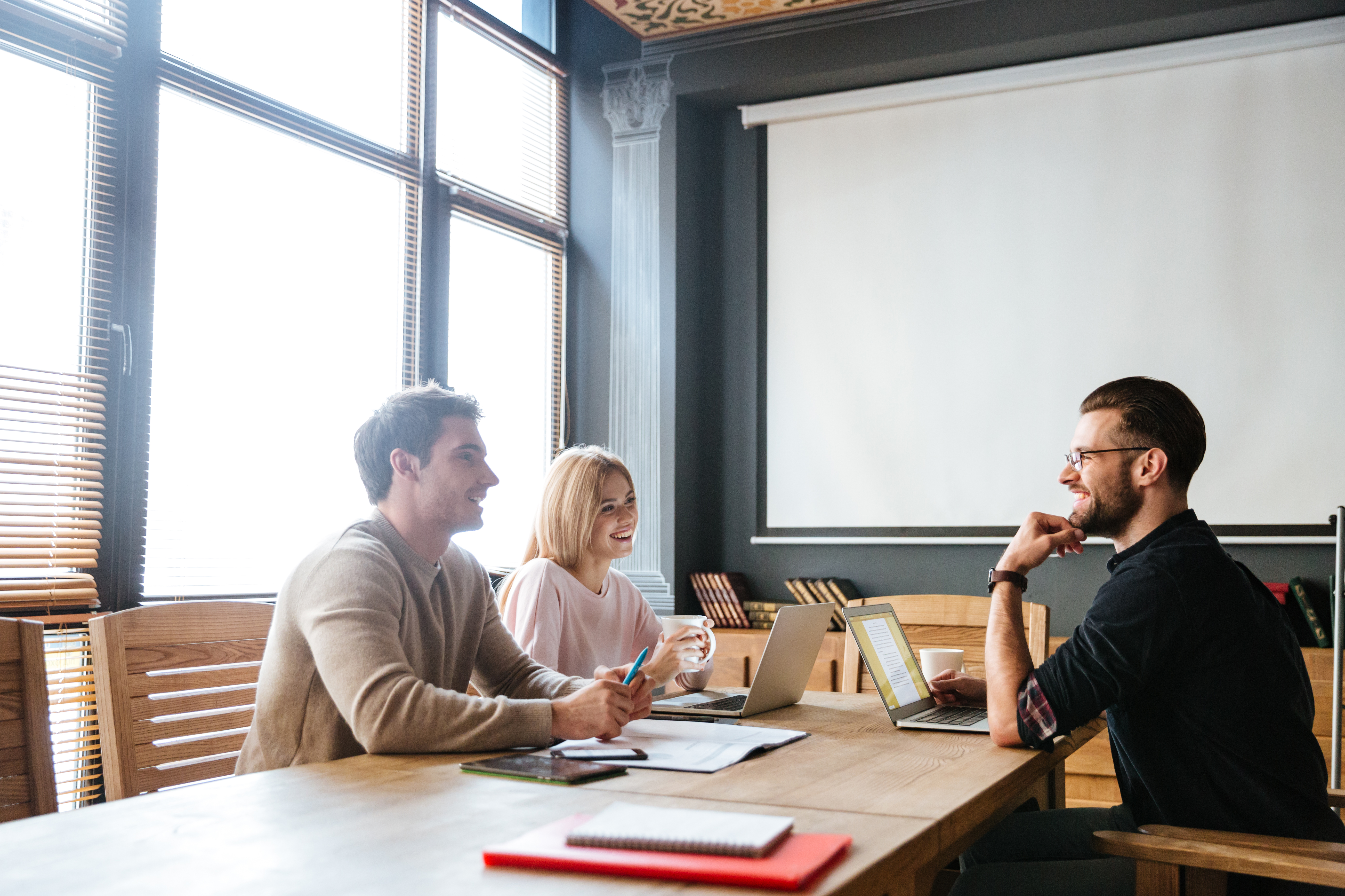 three-young-happy-colleagues-coworking